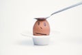 Spoon breaks sad egg on a stand in the form of human head . Royalty Free Stock Photo