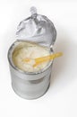 Spoon in can full of powdered baby milk formula isolated on whit Royalty Free Stock Photo