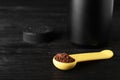 Spoon of chocolate protein powder on black wooden table Royalty Free Stock Photo