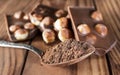 Spoon with cocoa powder and pieces of broken chocolate with nuts on the table. Close up Royalty Free Stock Photo