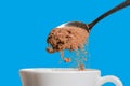 Spoon cocoa into a white mug