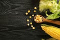 Spoon with corn kernels and cobs on wooden table Royalty Free Stock Photo