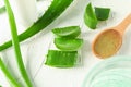 Spoon with cream, aloe vera leaves and slices on white table, closeup Royalty Free Stock Photo