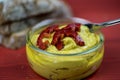 Spoon in curry hummus with hot pepper slices