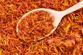 Spoon with dried safflower petals on dried flowers