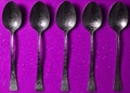 Spoon in a drop of water on a colored background Royalty Free Stock Photo
