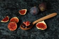 Spoon with fig jam and ingredients on black smokey background