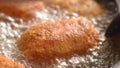 Dolly shot of Breaded Cutlets Sizzle in Frying Pan.