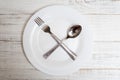 The spoon and fork are on an empty plate. Diet concept, intermittent fasting
