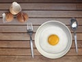 Spoon fork fried egg on plate on a Cream background Royalty Free Stock Photo