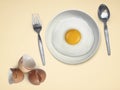Spoon fork fried egg on plate on a Cream background Royalty Free Stock Photo