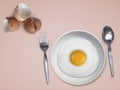 Spoon fork fried egg on plate on a Pink background Royalty Free Stock Photo