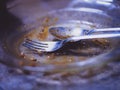 Used spoons and forks are placed in the food plate.