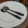 spoon and fork on white dinner plate Royalty Free Stock Photo