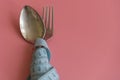 spoon and fork wrapped in tape measure on pink background. Proper nutrition. Medical starvation. Diet for weight loss concept. Royalty Free Stock Photo