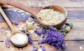 Spoon full of flakes of soap with essential oil andlavender flowers and  bicarbonate on wooden background Royalty Free Stock Photo