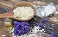 Spoon full of flakes of soap with essential oil and lavender flowers and sodium bicarbonate on wooden background Royalty Free Stock Photo