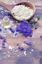 Spoon full of flakes of soap with essential oil of lavender flowers on wooden background Royalty Free Stock Photo