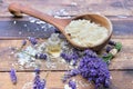 spoon full of flakes of soap with essential oil and lavender flowers on wooden background Royalty Free Stock Photo
