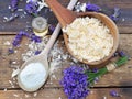 Spoon full of flakes of soap with essential oil and  lavender flowers and sodium bicarbonate on wooden background Royalty Free Stock Photo