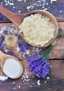 Spoon full of flakes of soap with essential oil and  lavender flowers and sodium bicarbonate on wooden background Royalty Free Stock Photo