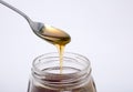 Spoon full of honey and glass jar