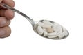 Spoon full of pills on a white background Royalty Free Stock Photo