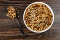 Spoon with granola, muesli with cereals, raisin and sunflower seeds in plate on table. Top view Royalty Free Stock Photo