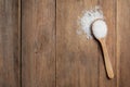 Spoon and heap of natural sea salt on wooden table, top view. Space for text Royalty Free Stock Photo