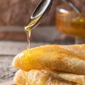 Spoon of honey flowing on stack of pancakes Food concept holida