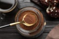 Spoon of instant coffee over jar on black wooden table, top view Royalty Free Stock Photo