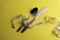 Spoon and Knife with a measuring tape, diet or healthy eating concept. Soft focus in middle Royalty Free Stock Photo