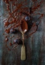 Spoon with liquid chocolate on a dark wooden background