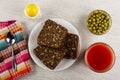 Spoon on napkin, bread with sunflower seeds in plate, salt, bowl with green peas, glass with tomato juice on table. Top view Royalty Free Stock Photo