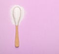 A spoon with natural sweetener lies on a pink background Royalty Free Stock Photo