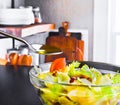 Spoon with olive oil on italian fresh salad and tomato on wood kitchen