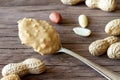 Spoon of peanut butter and peanuts on wooden boards, healthy nutritious snack