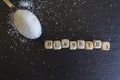 Spoon with pile of sugar and diabetes word written on wooden cubes