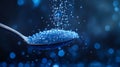 Spoon pouring blue crystal sugar on dark background with bokeh Royalty Free Stock Photo