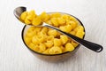 Spoon, raw pasta lumache in glass bowl on wooden table