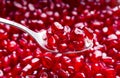Spoon and red pomegranate seeds