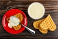 Spoon in red saucer with heart shaped cookies poured condensed milk, bowl with milk, biscuits on table. Top view Royalty Free Stock Photo