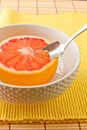 Spoon sectioning ruby red grapefruit Royalty Free Stock Photo