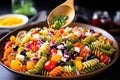 spoon serving colorful pasta salad