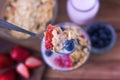 Spoon serving yogurt, cereal, strawberries and blueberries on a table - top Royalty Free Stock Photo