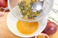 Spoon Squeezing Passion Fruit Pulps on a Strainer to Extract Liquid for Making Puree Royalty Free Stock Photo