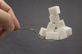 Spoon with stack of sugar cubes piled compared with cola refresh drink in sweet excess calories content, diet and glucose addictio Royalty Free Stock Photo