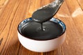 A spoon taking out black sesame paste