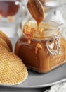 Spoon with tasty caramel sauce over jar on table. Selective Focus, Vertical Orientation. Close-up Royalty Free Stock Photo