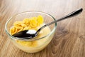 Spoon in bowl with corn flakes and fruit yogurt on wooden table Royalty Free Stock Photo